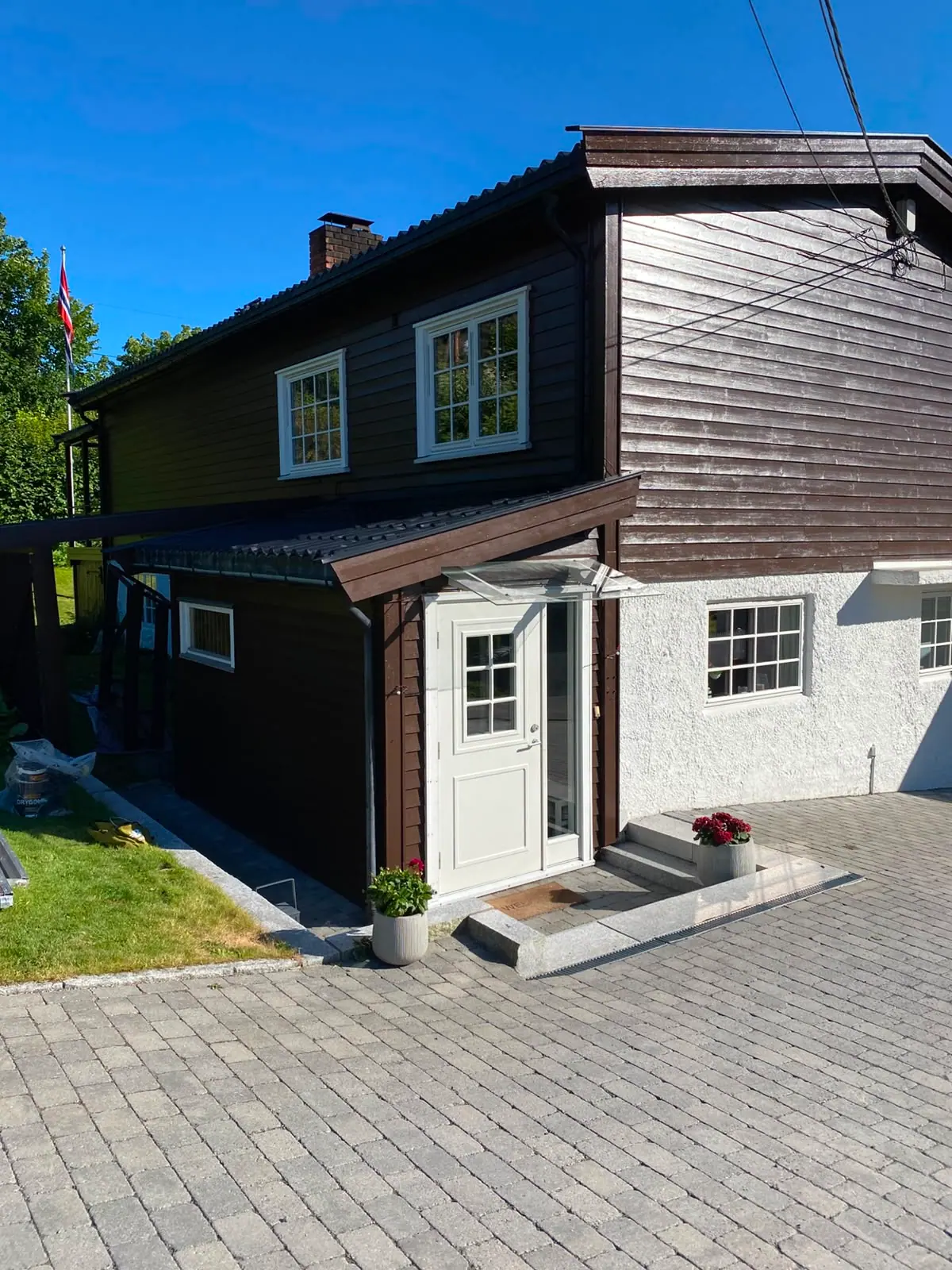 Bolig med mørk kledning og hvite vinduer, ferdig malt