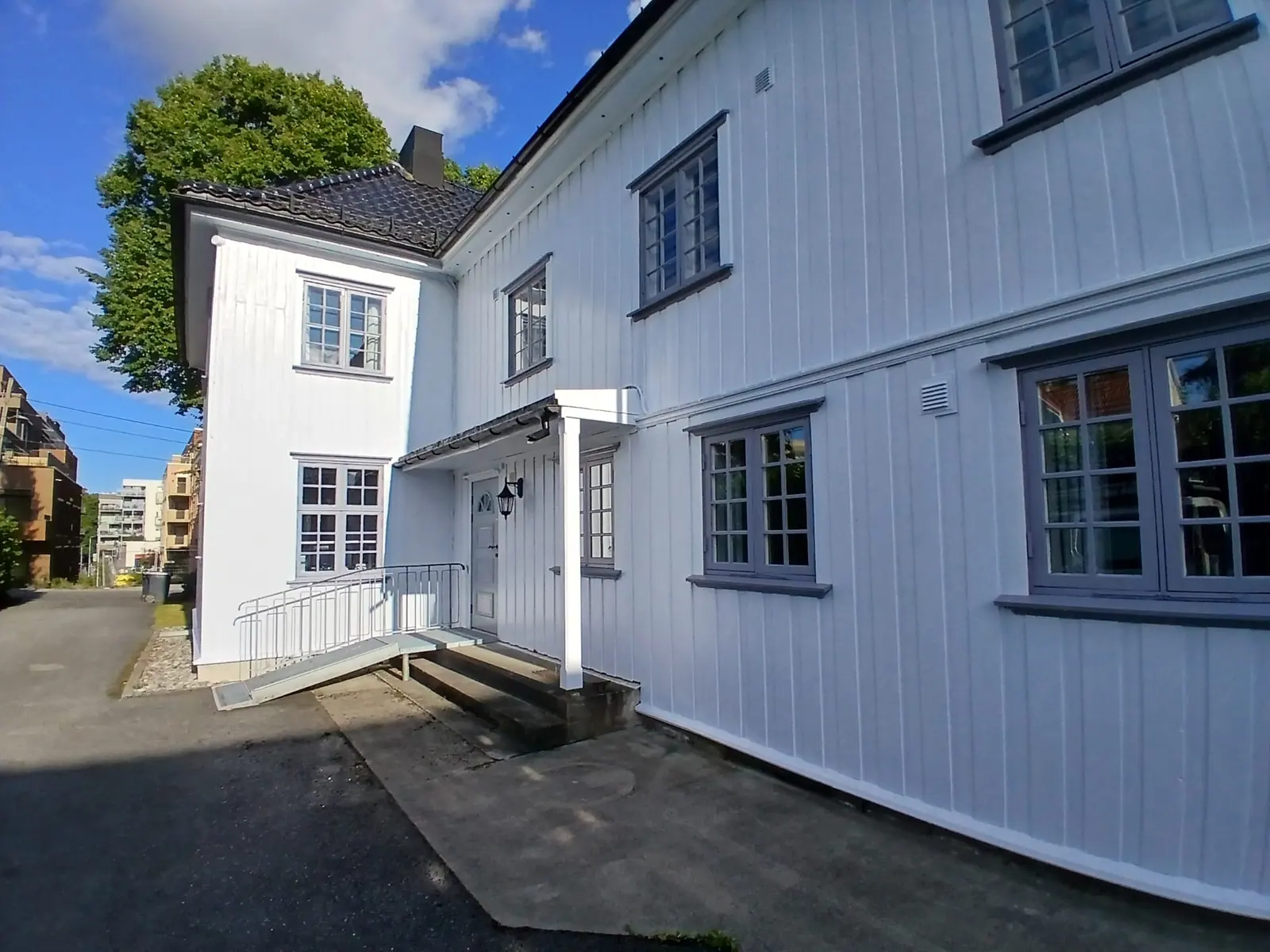 Hvit trebygning ferdig malt, sett fra hjørnet