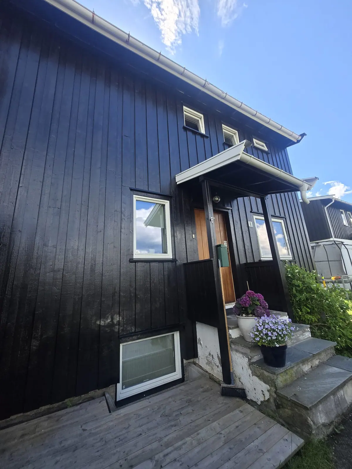 Inngangsparti på sort hus etter maling