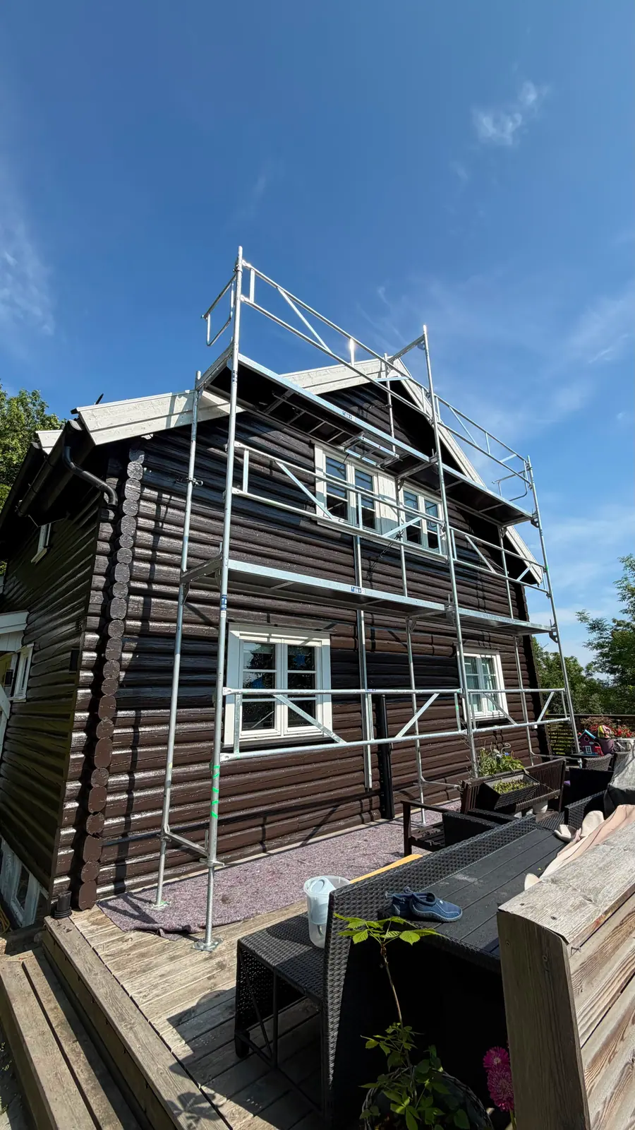 Tømmerhus med stillas før beising